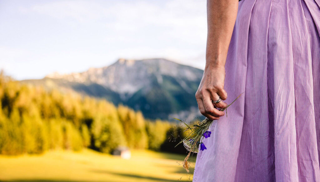 Gastgeberin in Dirndl auf der Alm vor dem Ötscher
