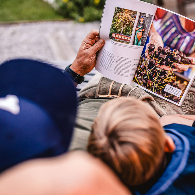 Vater relaxt in Chillout-Area beim Lesen mit Sohn